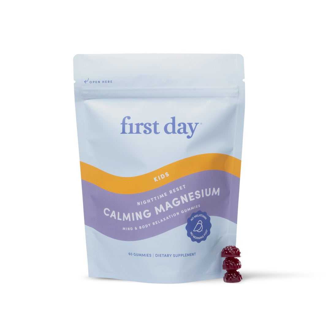 A pouch labeled Kids’ Nighttime Reset Calming Magnesium stands upright, with two red gummies beside it. The light blue packaging with purple and yellow accents emphasizes this calming supplement for kids&