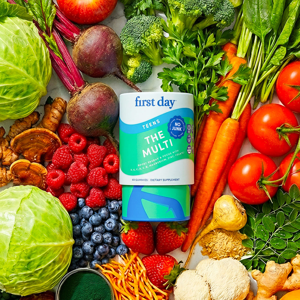 Vegetables behind a multivitamin bottle.