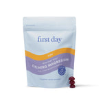 A pouch labeled Kids’ Nighttime Reset Calming Magnesium stands upright, with two red gummies beside it. The light blue packaging with purple and yellow accents emphasizes this calming supplement for kids' sleep support.