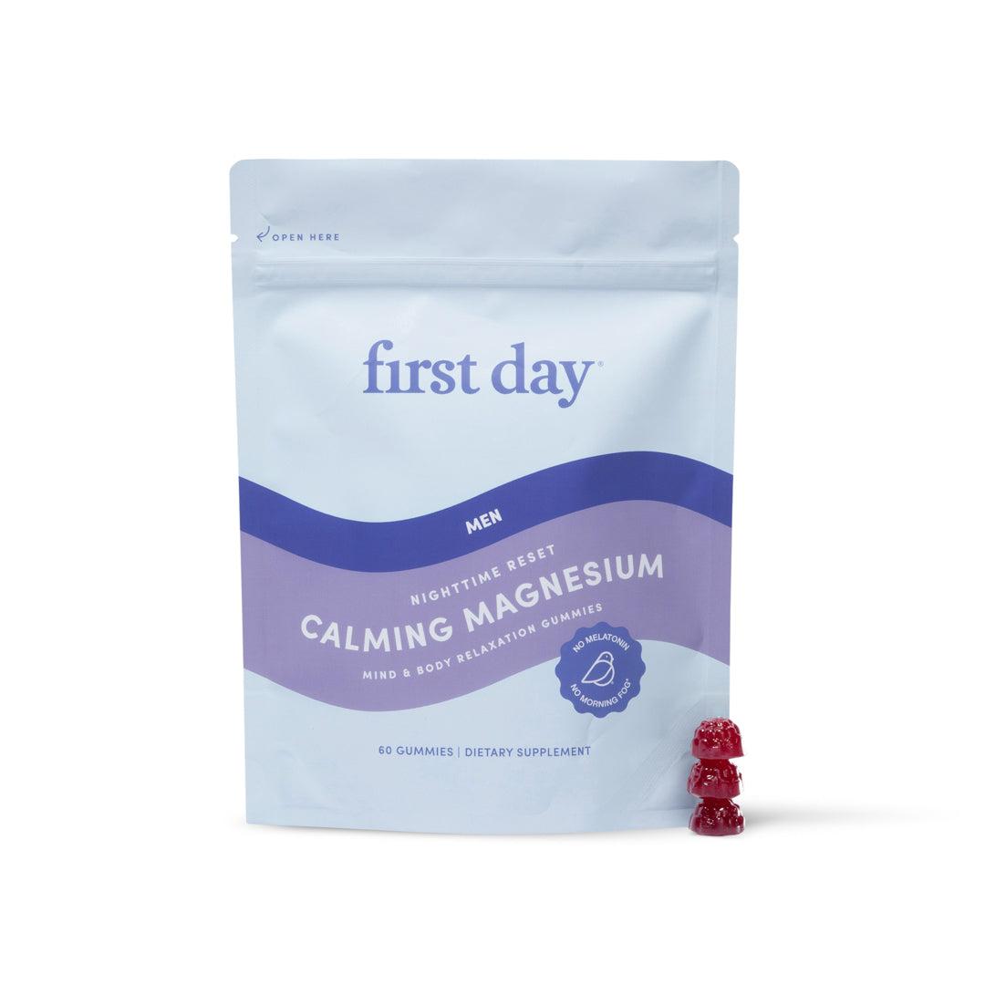 A light blue and purple pouch labeled “Men’s Nighttime Reset Calming Magnesium” stands upright, with three red bear-shaped gummies beside it. This melatonin-free supplement contains 60 gummies to support better sleep and relaxation.