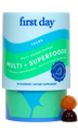 A container labeled first day Teens Multi + Superfoods with 60 gummies, described as a daily supplement with organic superfoods and multivitamins. Two gummies, one brown and one orange, are shown next to the container.