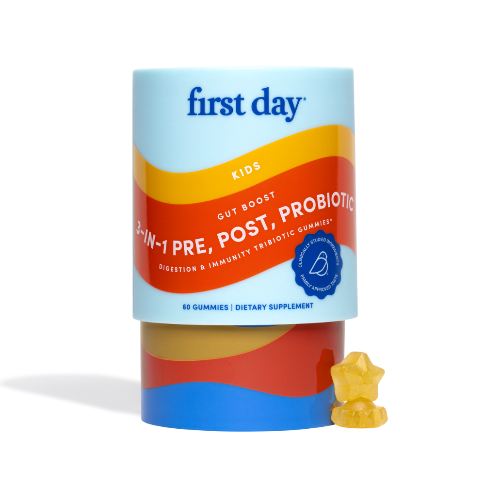 A container of First Day Kids Gut Boost 3-in-1 Pre, Post, Probiotic gummies with a colorful, curved label. Two yellow star-shaped gummies are placed in front of the container.