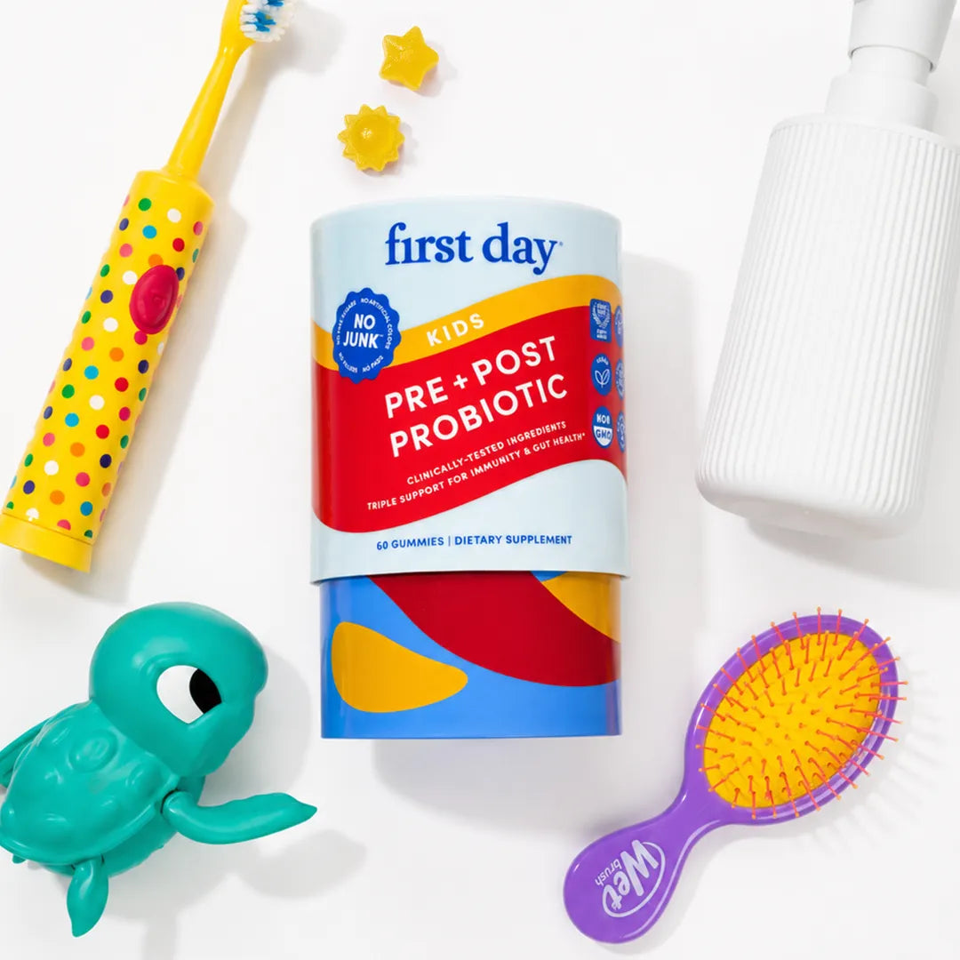 A cylindrical First Day Kids Pre + Post Probiotic container is centered on a white background, surrounded by colorful children&