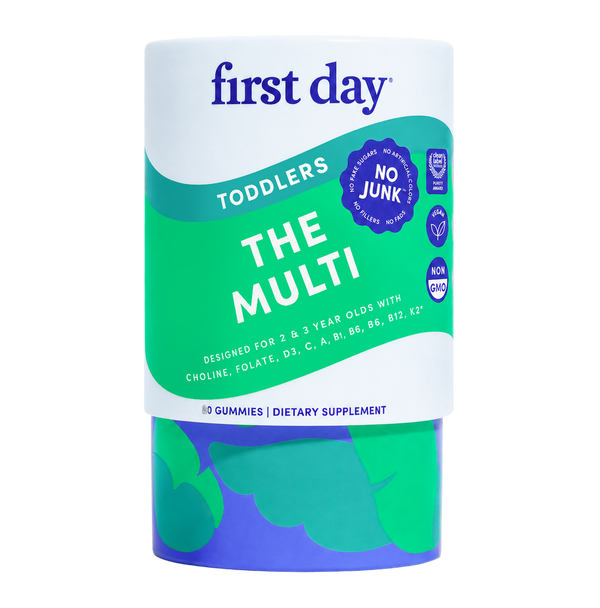 A cylindrical container of First Day Toddlers 'The Multi' dietary supplement gummies, featuring a white and green label with blue and purple accents, set against a plain white background.